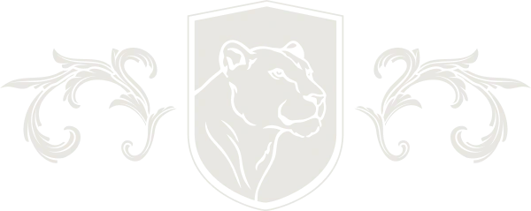 Desktop_Interior_Hero_Graphic A faint outline of a lioness head inside a shield, flanked by symmetrical decorative floral patterns on both sides, all in light gray on a white background.