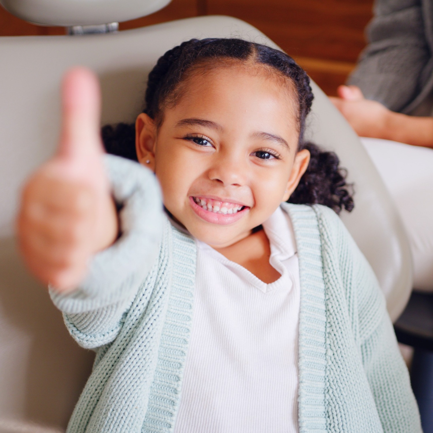AdobeStock_1846309222 v2 A smiling young girl in a dental chair gives a thumbs up in Wall Township NJ
